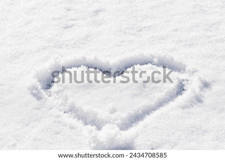 Heart picture on natural white snow texture background.