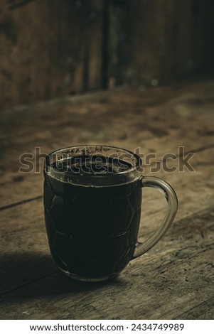 a glass of black coffee with a slightly bitter sweet taste. A typical taste of village coffee in the Central Java region of Indonesia