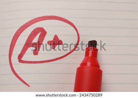 School grade. Red letter A with plus symbol on notebook paper and marker, top view