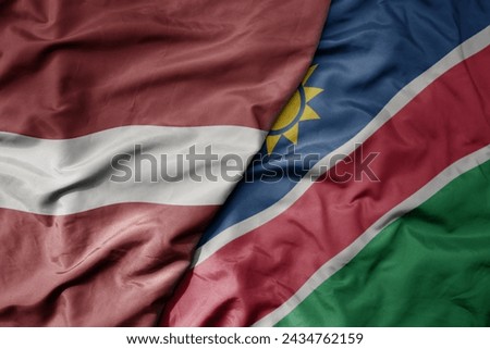 big waving national colorful flag of namibia and national flag of latvia. macro