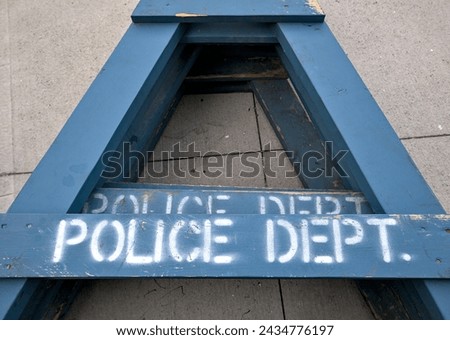 police dept (department) sign on blue wooden barricade laid on cement pavement sidewalk (painted stencil lettering) Royalty-Free Stock Photo #2434776197