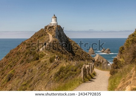 The 10-metre Nugget Point lighthouse, off the Southern Scenic Route, was first lit in 1870. Surrounded by rocky islets or nuggets, it was was automated in 1988.
 Royalty-Free Stock Photo #2434792835