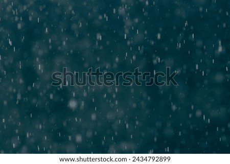 Blur Defocus Image of Abstract splashes of Rain and Snow Overlay Freeze motion of white particles on black background