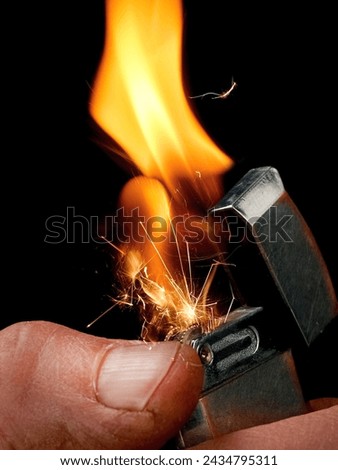 Start of gas lighter ignition with sparkles and explosion, close up Royalty-Free Stock Photo #2434795311