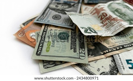Various international currencies and US dollars on a white surface.