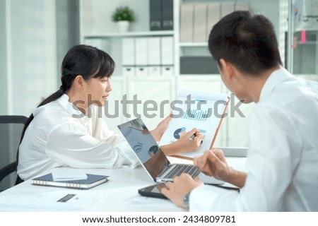 Group of Asian young businesspeople having a business discussion together in an office. Businesspeople talking and presenting a business report to her colleague.