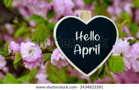 Hello April greeting card with decorative heart and pink spring flowers.Springtime concept with copy space.Selective focus. Royalty-Free Stock Photo #2434823381