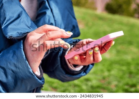 woman's hands holding and using smartphone