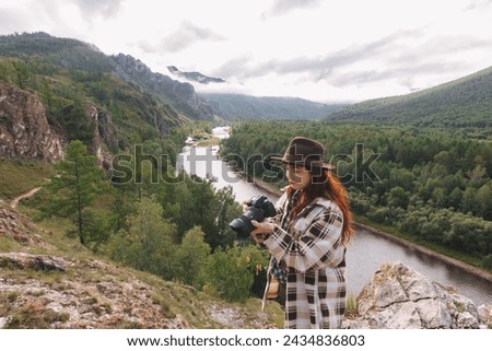 Landscape photographer a woman adjusts the camera while shooting mountains in Khakassia. The concept of freelancing, travel