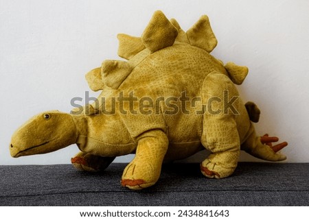 Photo of a beauty plush toy, dinosaur, stegosaurus, of green color 