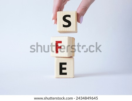 SFE - Sales Force Effectiveness. Wooden cubes with word SFE. Businessman hand. Beautiful white background. Business and Sales Force Effectiveness concept. Copy space.