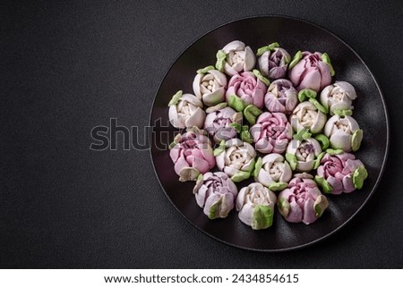 Beautiful tasty marshmallows in the form of tulip buds on a dark concrete background