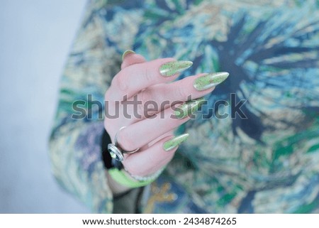 Female hand with long nails and light green manicure