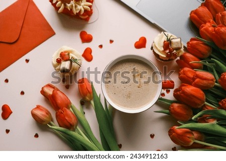 Cup of coffee, bouquet of red tulips and laptop top view flat lay, festive background.