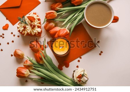 Candle and bouquet of red tulips, spring aesthetics.