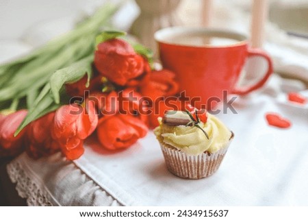 Cupcake, cup of coffee, tulips and candles, spring atmosphere.