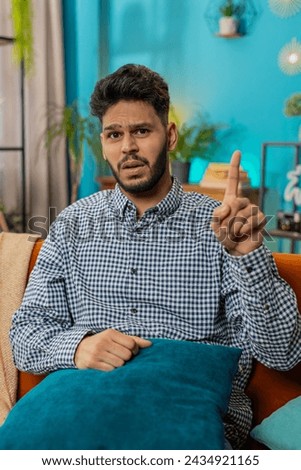 Displeased upset Indian young man reacting to unpleasant awful idea, dissatisfied with bad quality wave hand shake finger No dismiss idea don't like proposal. Hispanic guy sitting at home room couch Royalty-Free Stock Photo #2434921165