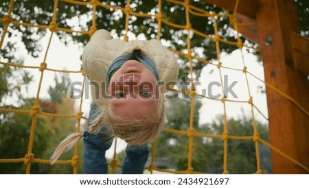 European playful girl play sports playground hanging climbing childish funny joy entertainment weekend active adventure lifestyle kid daughter health preschool motion recreation offspring city outside Royalty-Free Stock Photo #2434921697