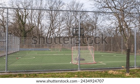 A park in the Swisshelm Park neighborhood with a fenced in area for hockey and basketball in Pittsburgh, Pennsylvania, USA as seen on a winter day