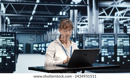 Certified employee working in server hub housing GPU dedicated supercomputers that can process AI tasks with high efficiency, adjusting rigs used for machine learning acting up Royalty-Free Stock Photo #2434931511