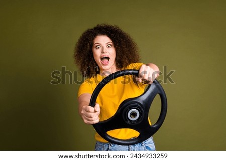 Photo of young surprised woman funny chevelure hair first time fast speed driving automobile alone isolated on khaki color background
