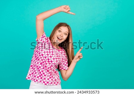 Photo portrait of lovely teen lady point excited empty space promo wear trendy print pink garment isolated on cyan color background