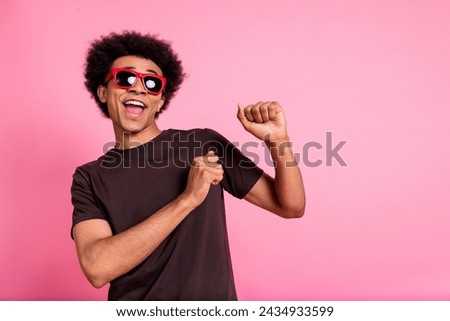 Portrait of carefree wavy hair man wear brown t shirt and sunglass rayban have fun chilling clubbing isolated on pink color background