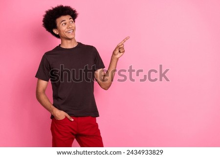 Photo of young guy wavy hair in brown t shirt directing finger empty space showing breaking news isolated on pink color background