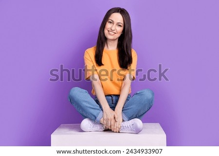 Full length body photo of brunette hair woman in yellow t shirt and jeans sitting podium satisfied glad isolated on violet color background Royalty-Free Stock Photo #2434933907
