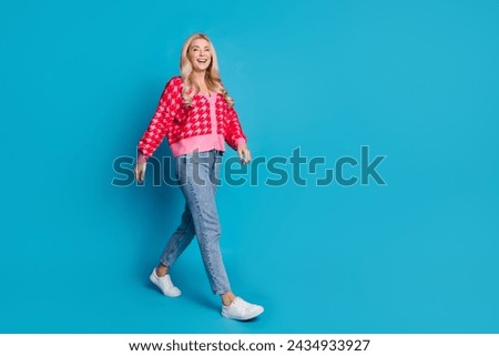 Full length photo of good mood cheerful woman wear knit print cardigan go shopping to empty space isolated on blue color background