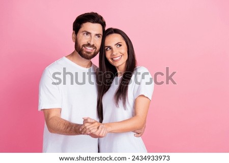 Photo portrait of attractive young couple hold hands look empty space dressed stylish white clothes isolated on pink color background