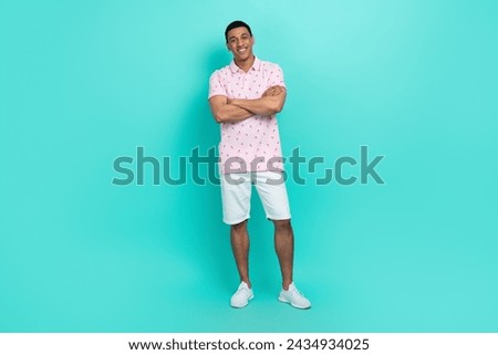 Full length photo of cool cheerful man wear print t-shirt white shorts standing hold arms crossed isolated on turquoise color background