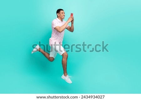 Full length photo of multiethnic multinational man recording video on smartphone run in empty space isolated on turquoise color background Royalty-Free Stock Photo #2434934027