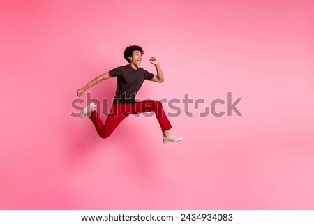 Full body length photo of young funky curly hair positive guy jumping running marathon rush hurry up isolated on pink color background