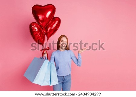 Photo of positive good mood woman hold heart bubbles new clothes in bags arm show object empty space isolated on pink color background