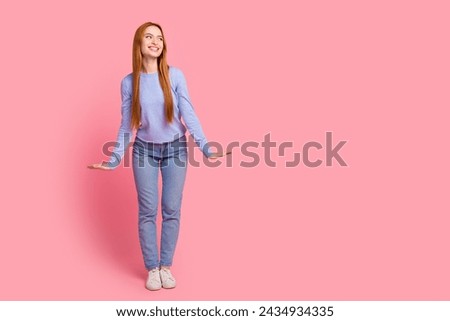Full size photo of cute woman dressed blue shirt jeans hold hands like doll look at sale empty space isolated on pink color background