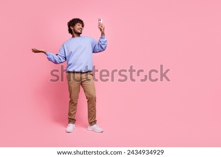 Full size photo of nice young guy video call streaming talking wear trendy blue outfit isolated on pink color background