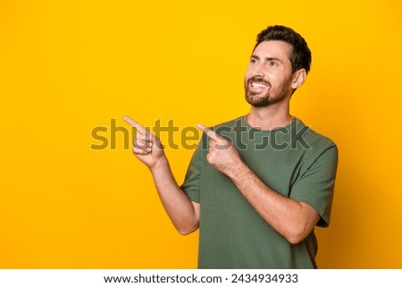 Photo of excited thoughtful guy dressed green t-shirt showing two fingers empty space isolated yellow color background