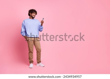 Full size photo of nice young guy device instagram twitter facebook telegram dressed stylish blue outfit isolated on pink color background