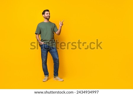 Full length photo of nice young male point look empty space dressed stylish khaki garment isolated on yellow color background