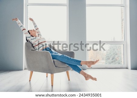 Full size photo of peaceful pretty girl sit stretching comfy chair free time bright spacious house inside