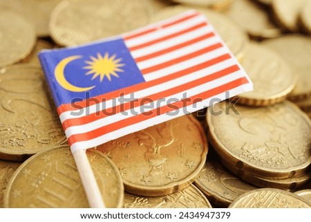 Malaysia flag on coin and banknote money, finance trading investment business currency concept. Royalty-Free Stock Photo #2434947379