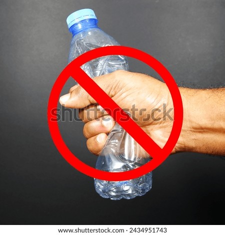 Empty plastic bottle crushed by hand with ban sign closeup shot, No plastic uses concept photography with warning or alert sign close-up view 