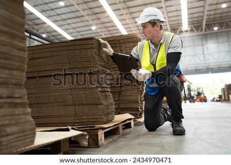 Caucasian foreman or businessman use clipboard checking Kraft paper stock at warehouse	