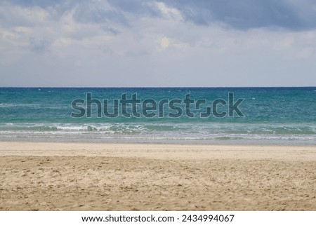 Empty beach with sea waves in the background and a clean sandy breeze