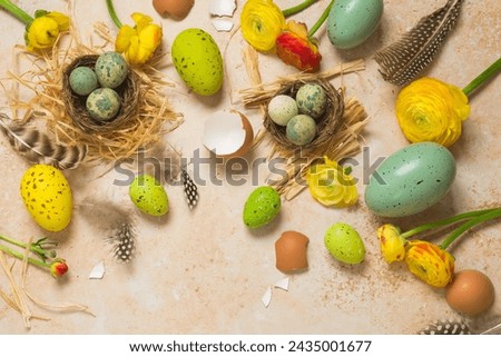 Easter holiday concept with easter eggs and spring flowers on stone background. Top view, flat lay composition
