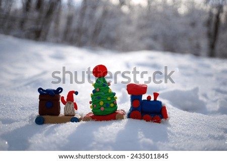 A toy train with a Christmas tree and plasticine gifts.