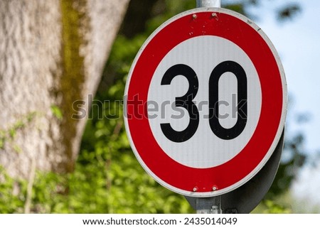 Urban safety and eco-friendly initiative: A daytime photo capturing a traffic sign in a speed limit 30 zone, highlighting the global trend of cities adopting lower speed limits to enhance road safety.