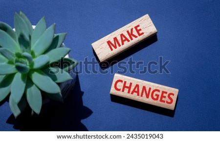 Make changes symbol. Wooden blocks with words Make changes with succulent plant. Beautiful deep blue background. Business and Make changes concept. Copy space.