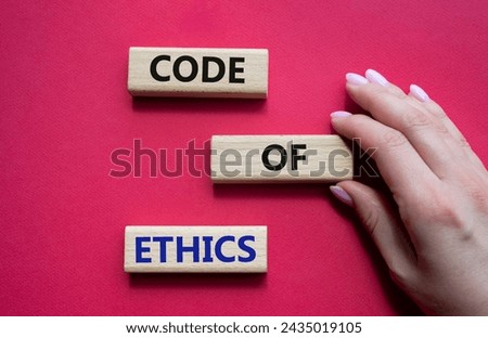 Code of ethics symbol. Concept words Code of ethics on wooden blocks. Beautiful red background. Businessman hand. Business and Code of ethics concept. Copy space.
